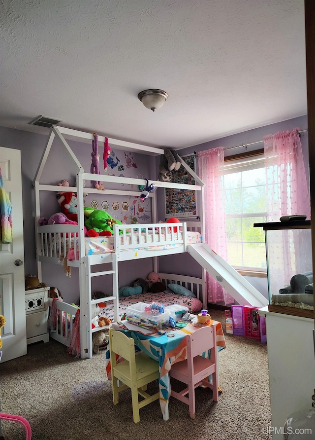bedroom with visible vents, a textured ceiling, and carpet flooring