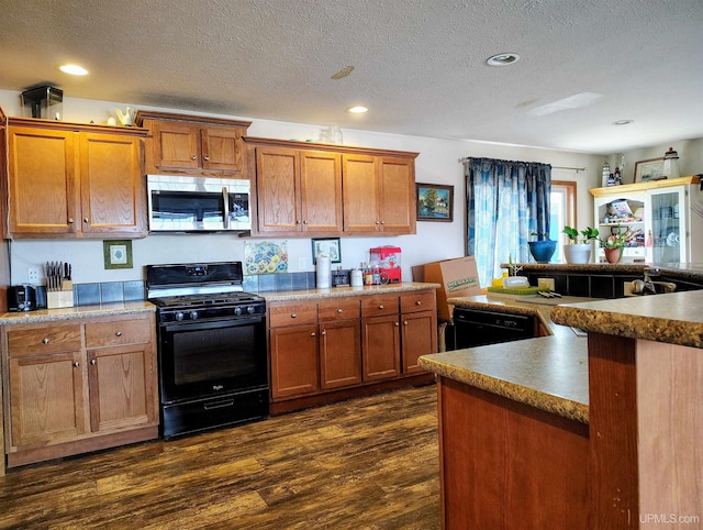 kitchen with dark wood-style floors, black appliances, and brown cabinets