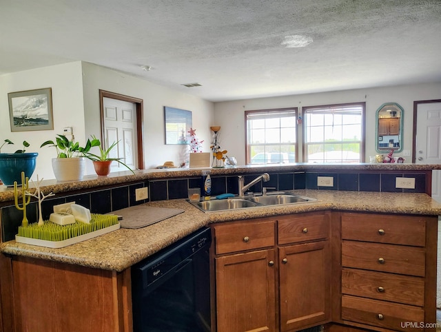 kitchen with visible vents, brown cabinets, dishwasher, and a sink