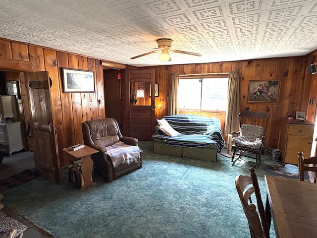 living room featuring wood walls, an ornate ceiling, a ceiling fan, and carpet floors