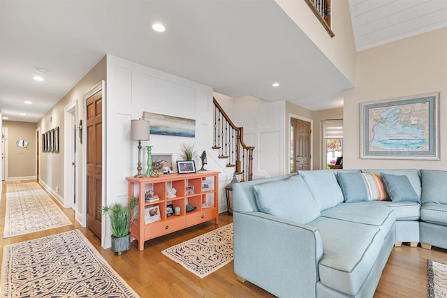 living area with stairway, light wood-style floors, and recessed lighting