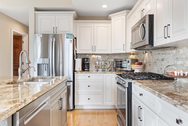 kitchen featuring white cabinets, a toaster, appliances with stainless steel finishes, and a sink