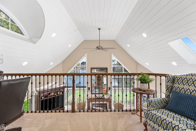 sitting room featuring lofted ceiling with skylight, recessed lighting, a ceiling fan, and carpet