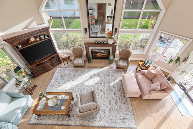 living room with wood finished floors, a healthy amount of sunlight, and a tile fireplace