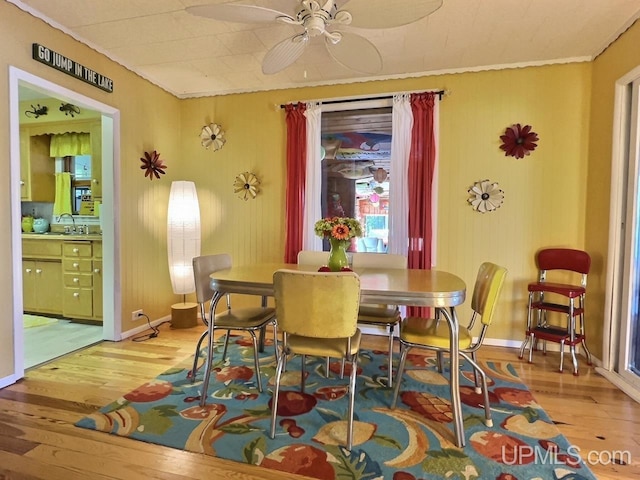 dining room featuring wood finished floors, ceiling fan, and baseboards