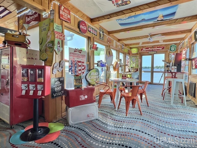 sunroom / solarium featuring beamed ceiling and a water view