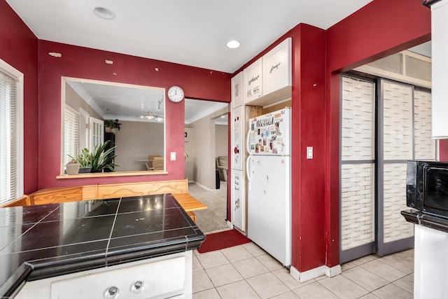 kitchen featuring light tile patterned floors, recessed lighting, freestanding refrigerator, and baseboards