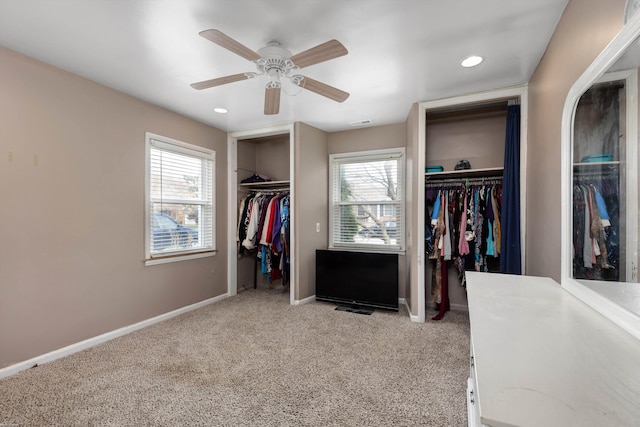 walk in closet featuring ceiling fan and light carpet