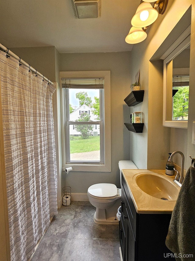 full bath with stone finish flooring, toilet, vanity, baseboards, and visible vents