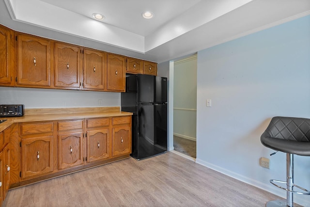 17769 Edloytom Way Unit 253, Clinton Township, MI 48038 - kitchen featuring freestanding refrigerator, brown cabinetry, light countertops, baseboards, and light wood-type flooring