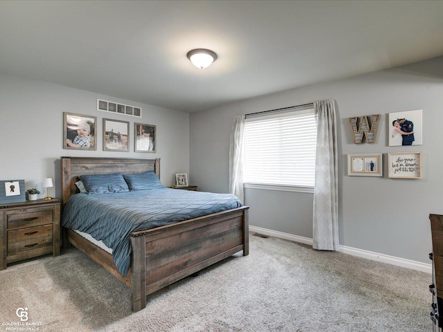 carpeted bedroom featuring baseboards and visible vents