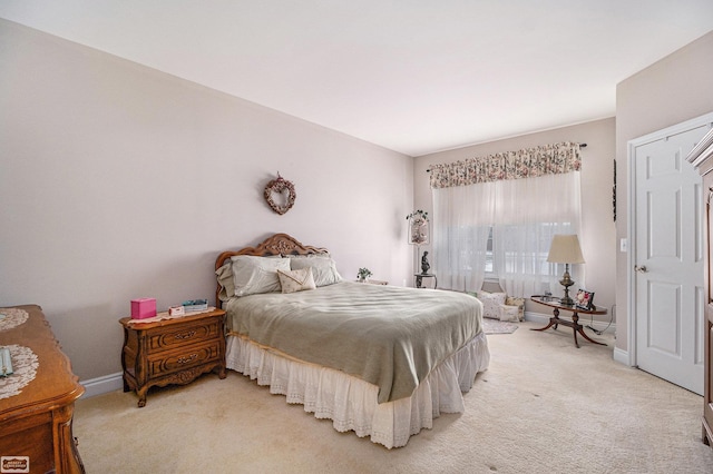 bedroom with baseboards and light carpet