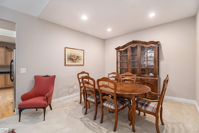 dining space with recessed lighting, baseboards, and light colored carpet