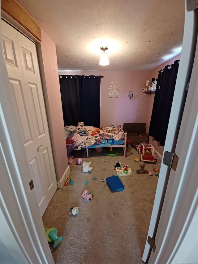 bedroom featuring baseboards, a textured ceiling, and carpet
