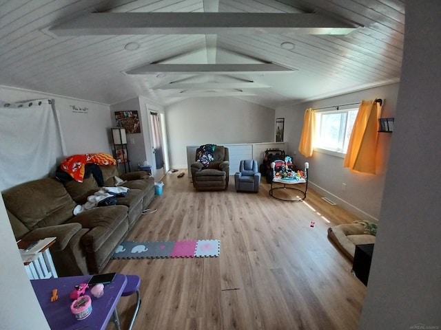 living room featuring wood finished floors, vaulted ceiling, and baseboards