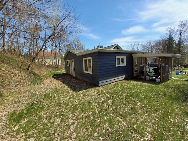 rear view of property with a yard and a sunroom