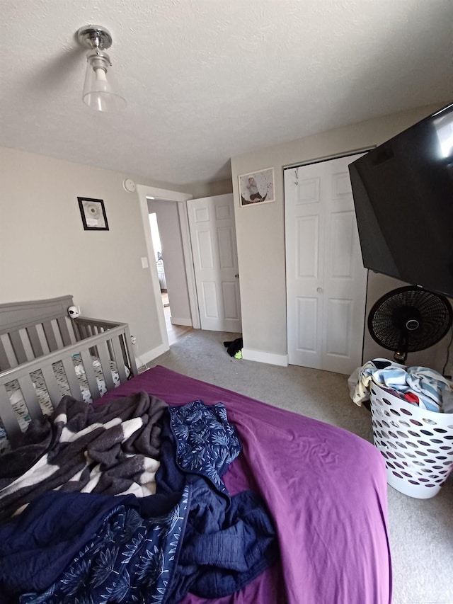 carpeted bedroom featuring a closet and baseboards
