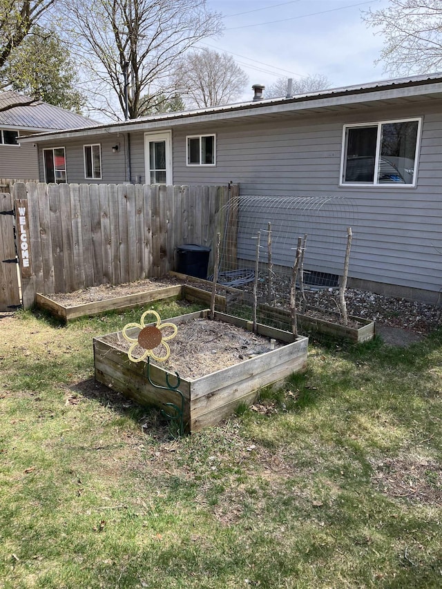 view of yard featuring fence and a vegetable garden