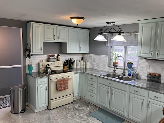 kitchen featuring a sink, decorative light fixtures, backsplash, and electric range