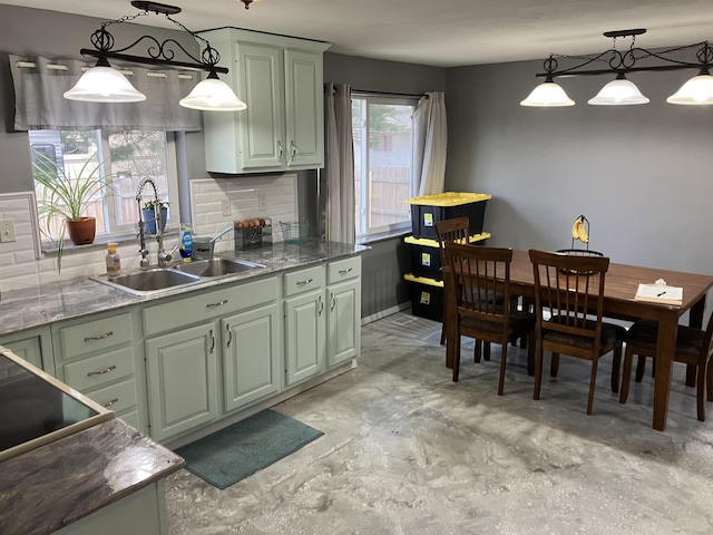 kitchen featuring pendant lighting, concrete flooring, black electric stovetop, and a sink