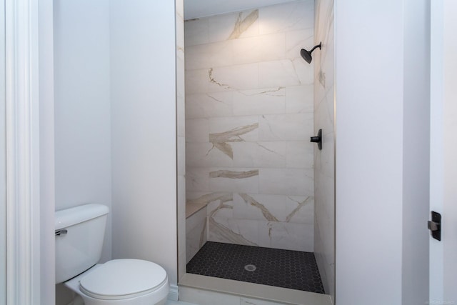 bathroom with toilet and a tile shower