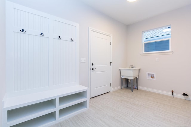 mudroom with a sink and baseboards