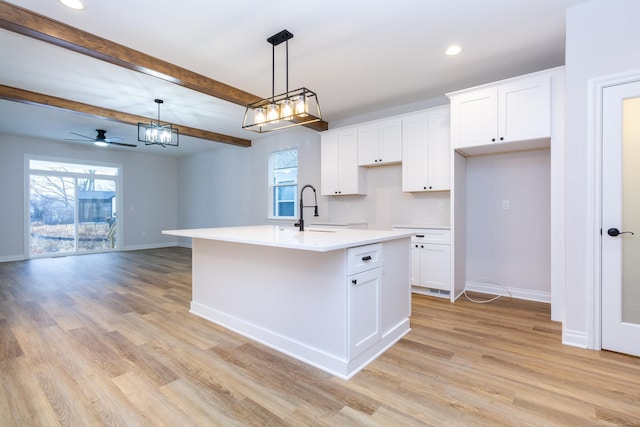 kitchen with baseboards, light wood-style flooring, and a sink