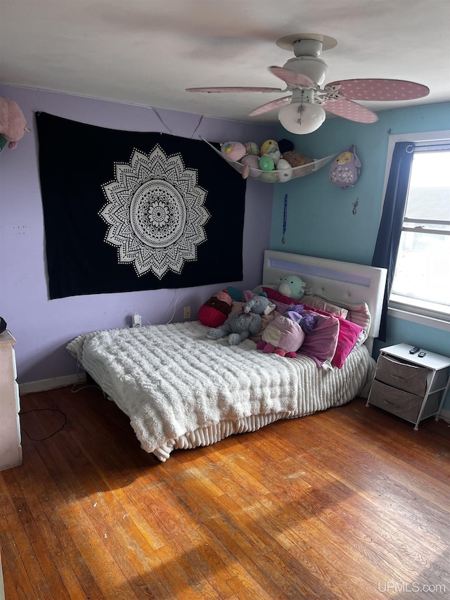 bedroom featuring a ceiling fan, hardwood / wood-style floors, and baseboards