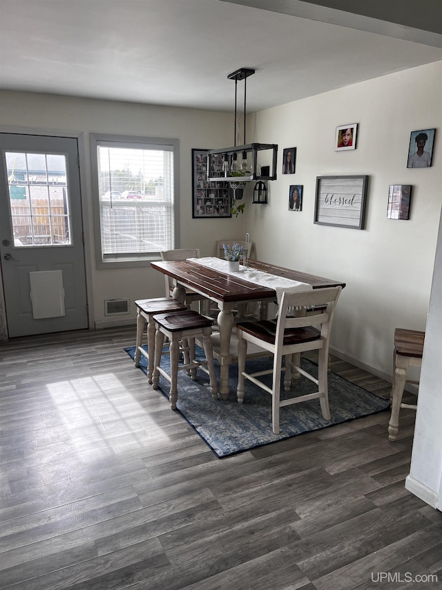 dining area featuring baseboards, visible vents, and dark wood-style flooring