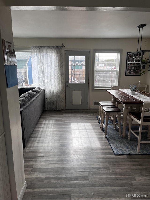 dining room with wood finished floors and a healthy amount of sunlight