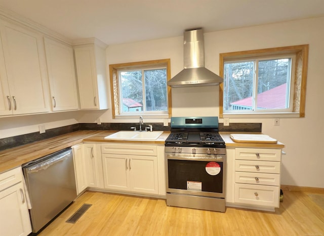 4358 Lakeshore Rd, Lexington, MI 48450 - kitchen featuring a sink, light wood-type flooring, visible vents, wall chimney range hood, and appliances with stainless steel finishes