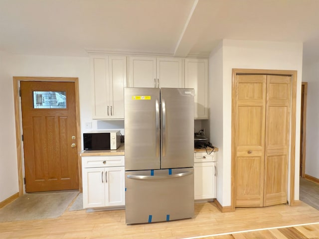 4358 Lakeshore Rd, Lexington, MI 48450 - kitchen with light wood-style floors, white microwave, white cabinetry, baseboards, and freestanding refrigerator