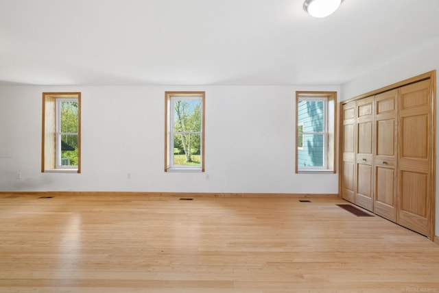 4358 Lakeshore Rd, Lexington, MI 48450 - unfurnished bedroom featuring visible vents, light wood-type flooring, multiple windows, and baseboards