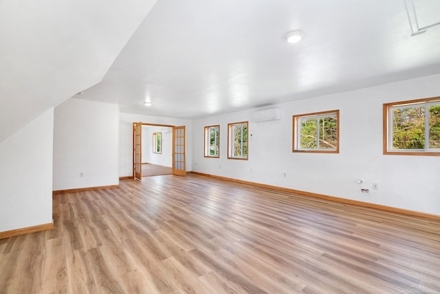 4358 Lakeshore Rd, Lexington, MI 48450 - unfurnished living room featuring a wall unit AC, light wood-style flooring, and baseboards