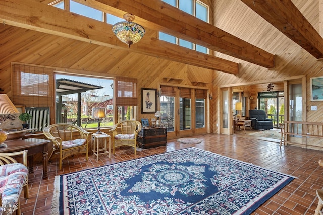 living room featuring high vaulted ceiling, wood walls, and beam ceiling