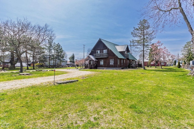 view of side of home featuring a lawn and metal roof