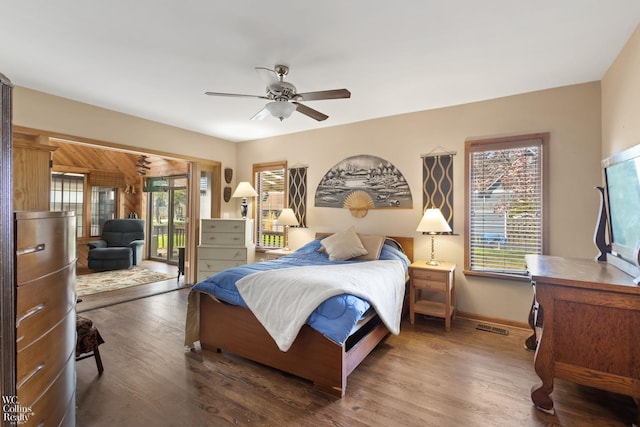 bedroom featuring wood finished floors, visible vents, access to exterior, and multiple windows
