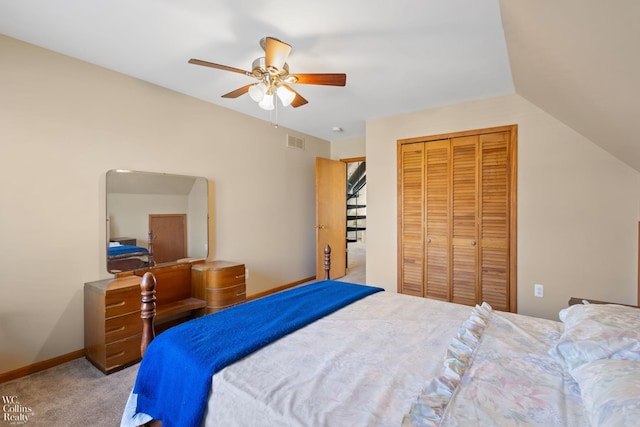 carpeted bedroom featuring a closet, vaulted ceiling, ceiling fan, baseboards, and visible vents