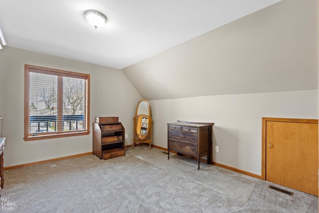 sitting room with baseboards, visible vents, carpet floors, and vaulted ceiling
