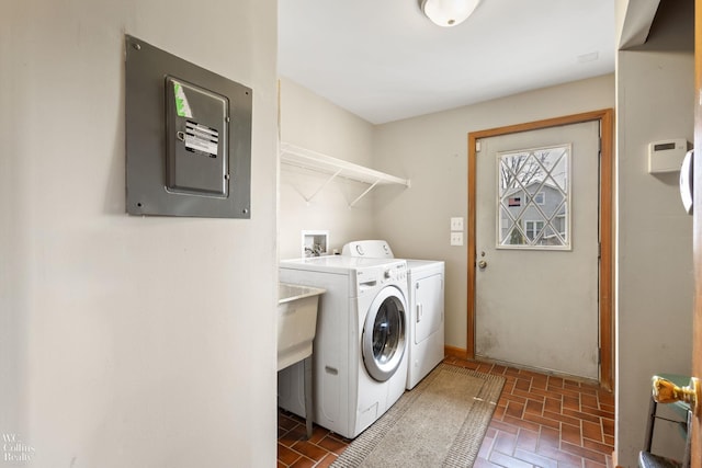 laundry room with electric panel, brick floor, laundry area, and washer and clothes dryer