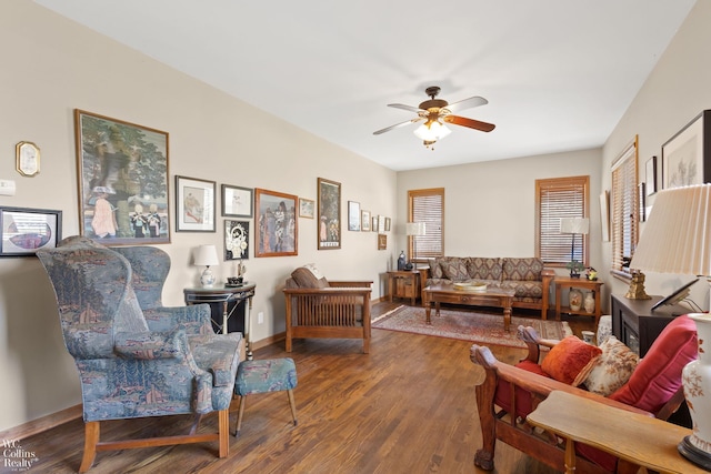 living area featuring baseboards, wood finished floors, and a ceiling fan