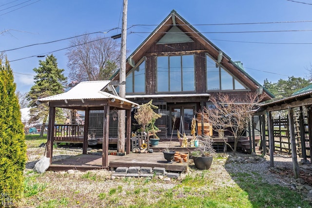rear view of house featuring a gazebo and a deck