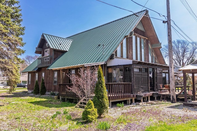 back of property with a deck, a standing seam roof, and metal roof
