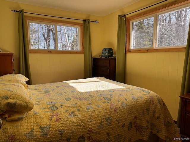 bedroom featuring wood walls
