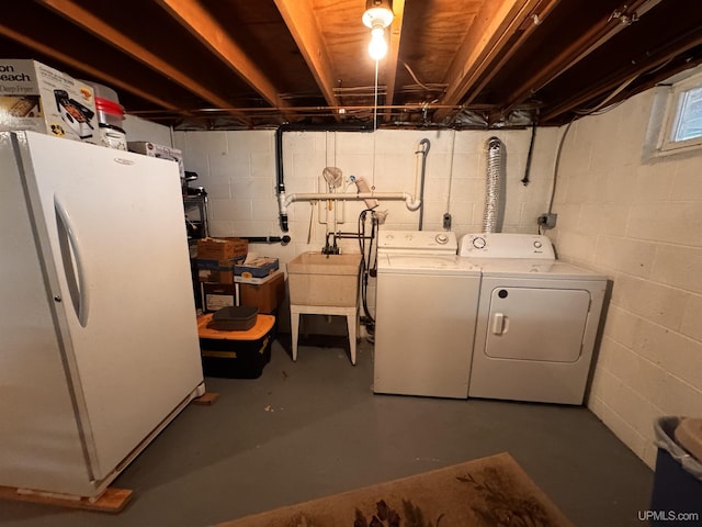 clothes washing area featuring washer and clothes dryer, laundry area, and a sink