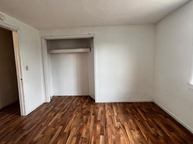 4110 N Clare Ave, Harrison, MI 48625 - unfurnished bedroom with a closet, a textured ceiling, and dark wood-style flooring