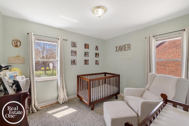 bedroom featuring a crib and baseboards