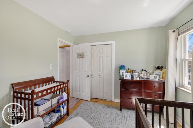 bedroom with light wood-style floors and a closet