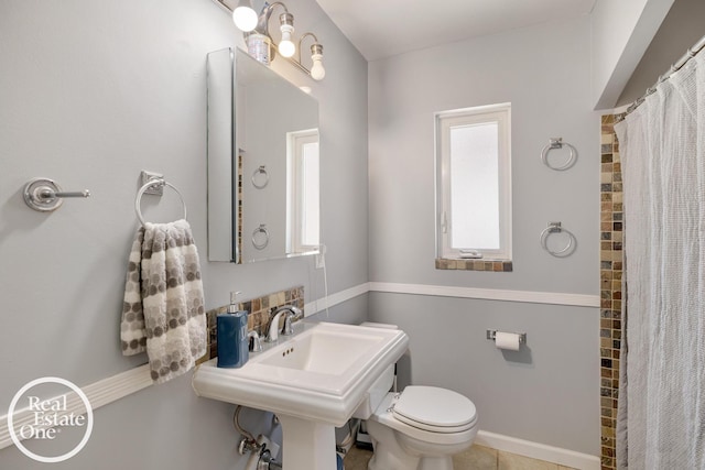 full bathroom featuring toilet, a shower with curtain, and a healthy amount of sunlight