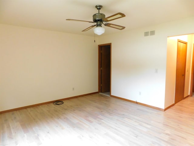 spare room with a ceiling fan, baseboards, visible vents, and light wood-style flooring